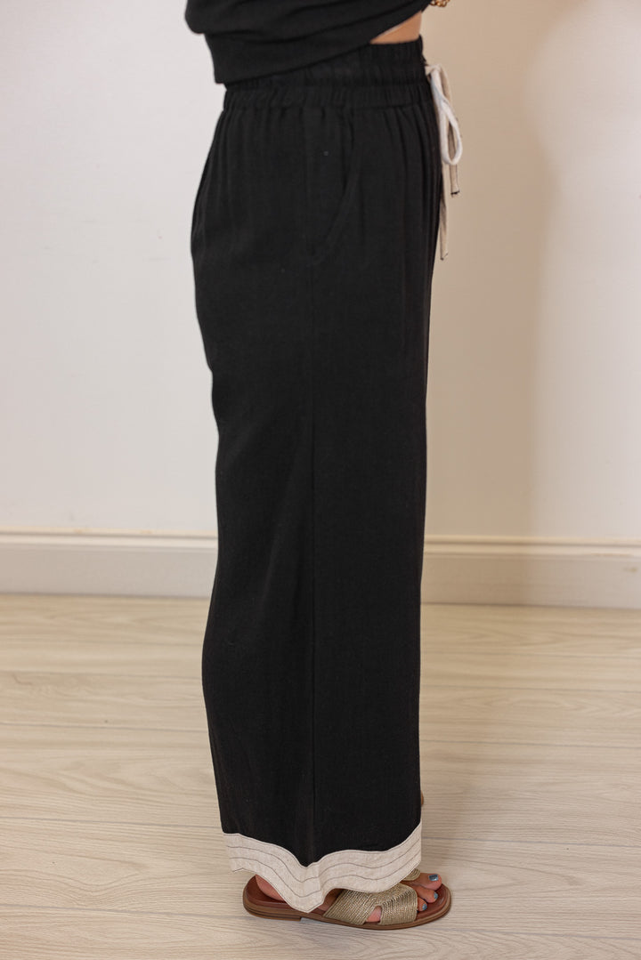 Umgee linen wide leg pants in black with oatmeal scalloped hem by Umgee showing side view