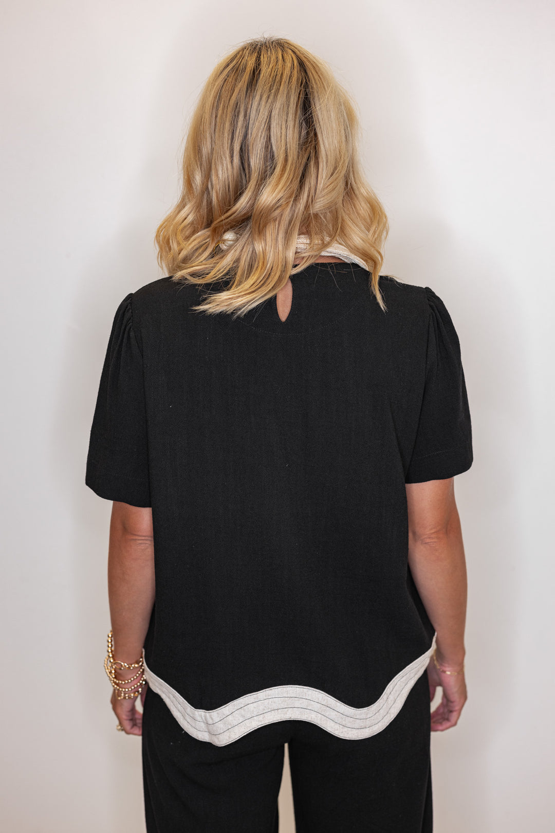 Women's linen top in black with oatmeal scalloped bottom hem by Umgee showing back view