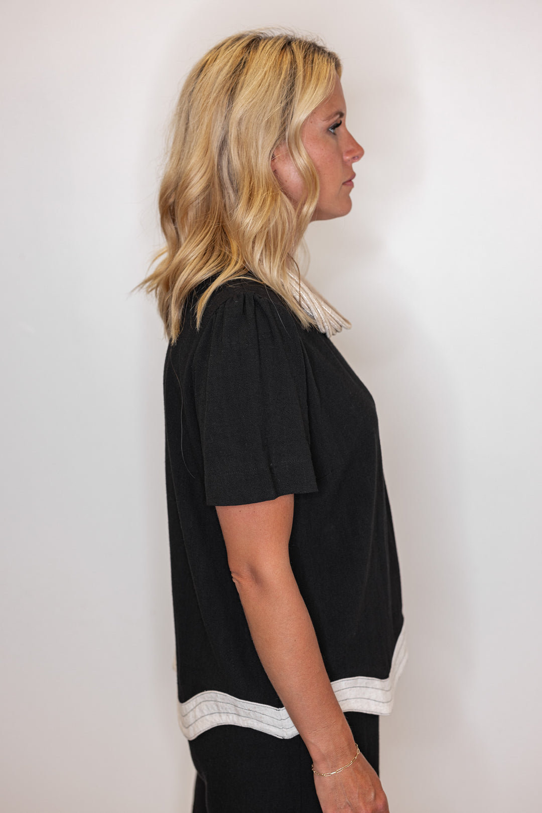 Women's linen top in black with oatmeal scalloped bottom hem by Umgee showing side view