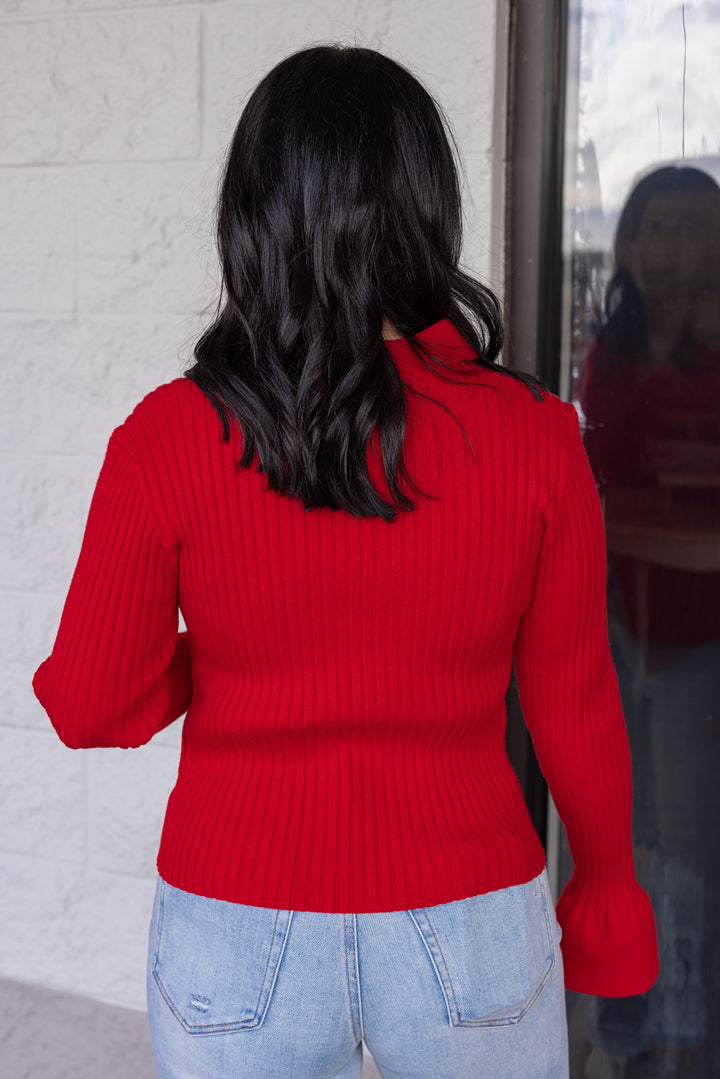 Women's red ribbed sweater knit top with a twisted front and peekaboo shoulders by So Me showing up close back view