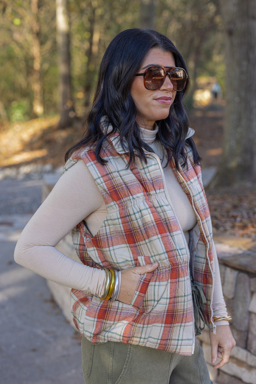 Women's quilted puffer vest in taupe, brown, persimmon orange and green plaid by Easel showing up close side view