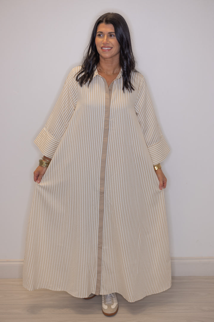 Women's striped light beige maxi dress by Entro showing flattering flowy skirt